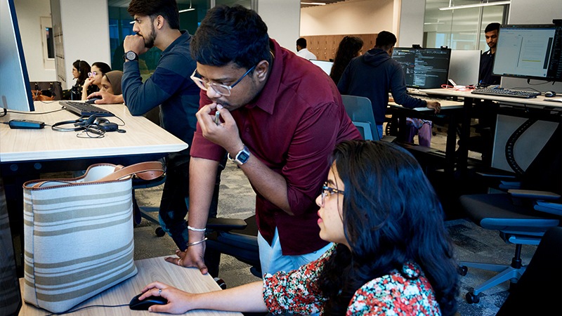 Sejal and a colleague work at a desk